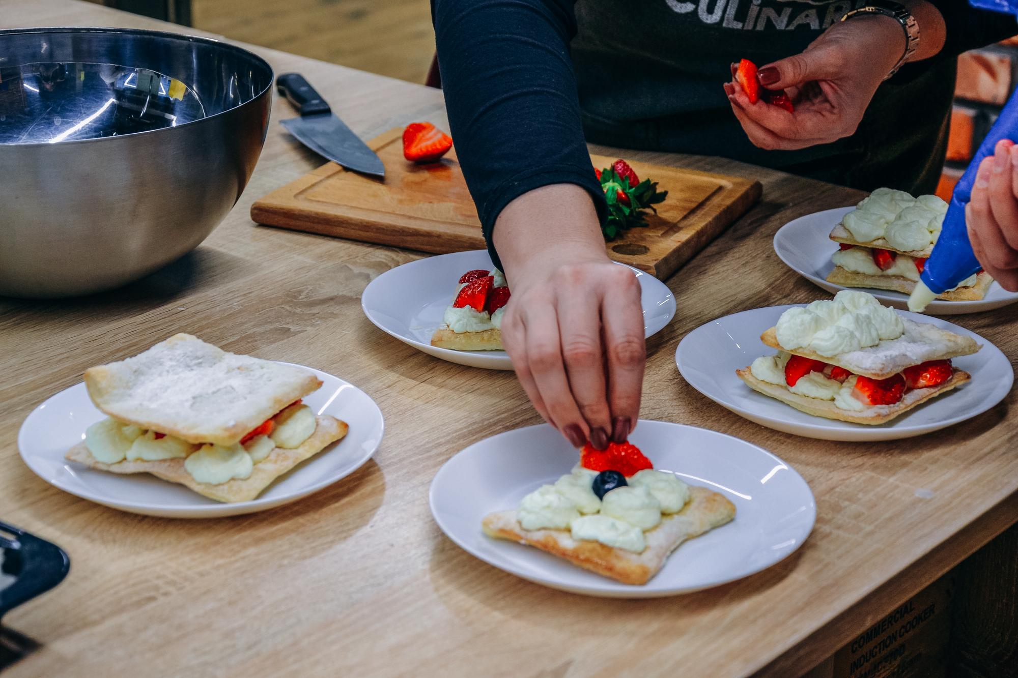 Students plating dessert on wooden board